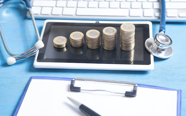 stethoscope and coins stacked on a tablet