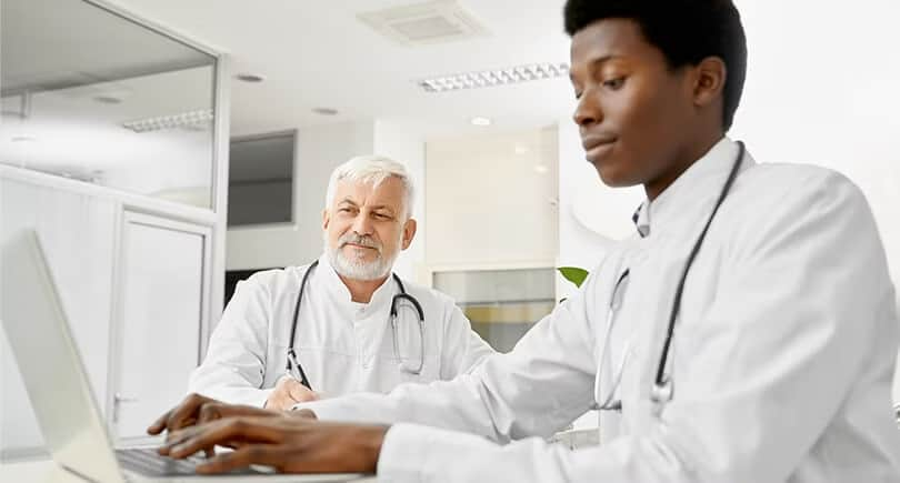 Two men sitting in white coats