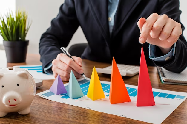 A hand touching the tallest paper triangle on a table